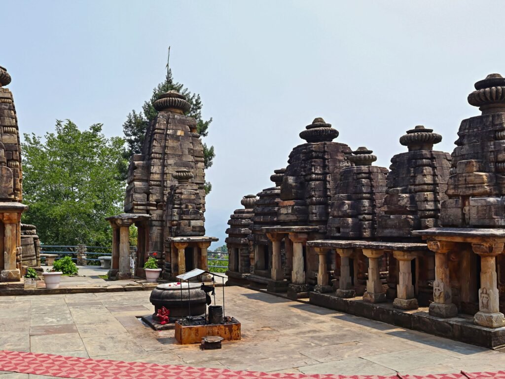 Several small, ancient stone temples with tiered roofs at the Katarmal Sun Temple.