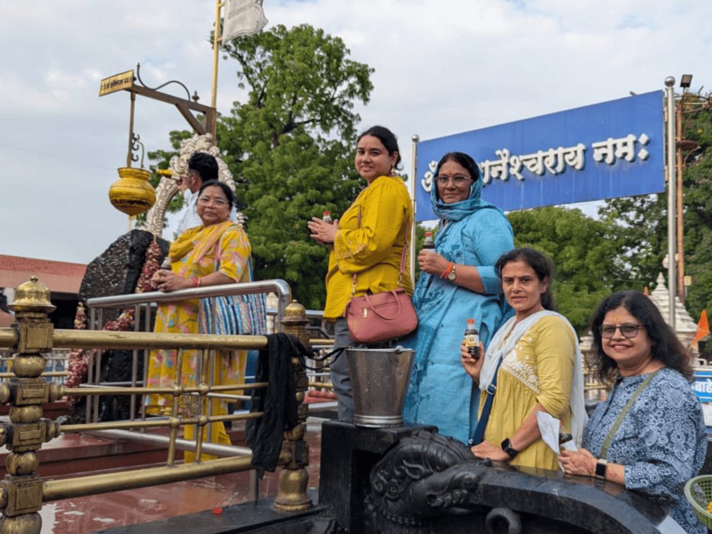 Members of the Transforming Travel group holding oil bottles while participating in the Tailabhishekam ritual at the Shani Shingnapur Temple.