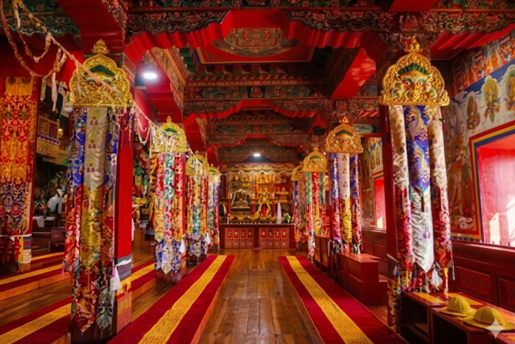 Ornate prayer hall inside Tawang Monastery with colorful murals and intricate wooden architecture