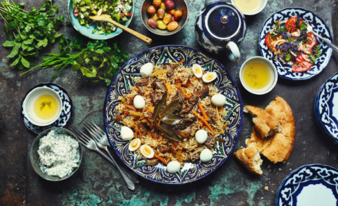 Uzbekistan food table with plov bread salads and tea traditional meal