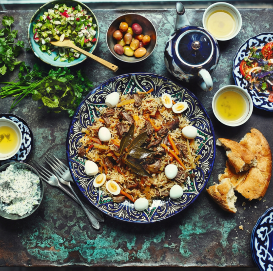Uzbekistan food table with plov bread salads and tea traditional meal