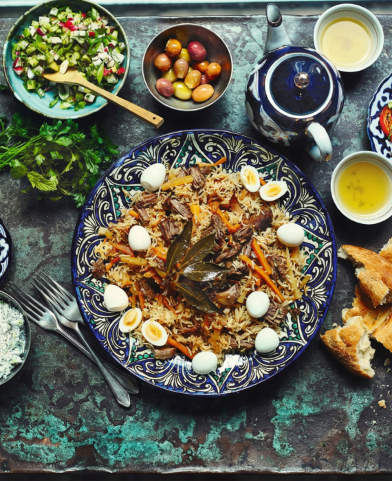 Uzbekistan food table with plov bread salads and tea traditional meal