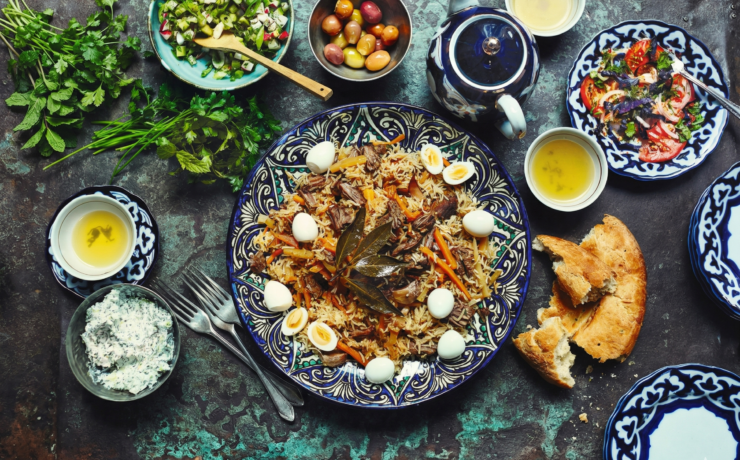 Uzbekistan food table with plov bread salads and tea traditional meal